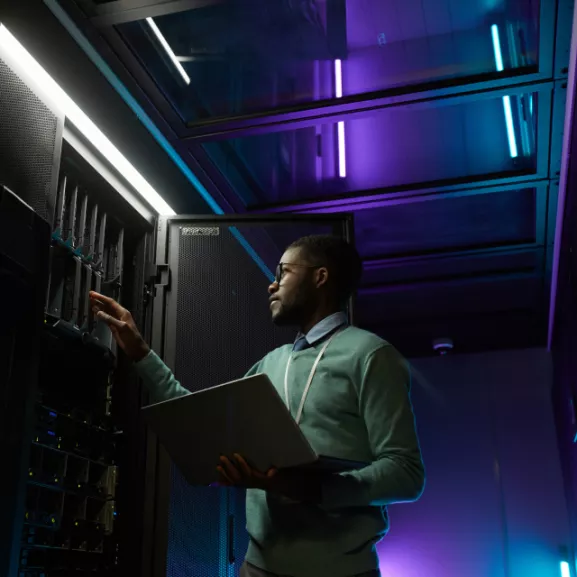 Technician reviewing open electric control panel with manual in hand