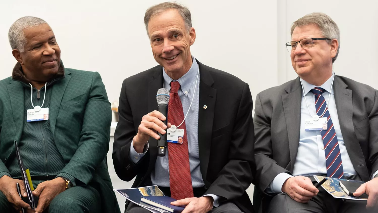 three men on panel at a talk.