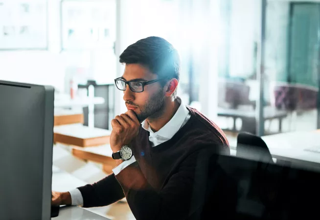 Man with glasses using computer.