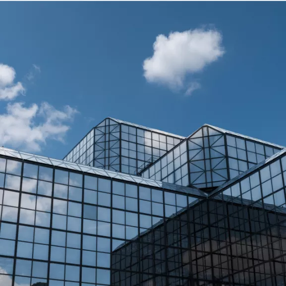 A building with glass windows and a blue sky.