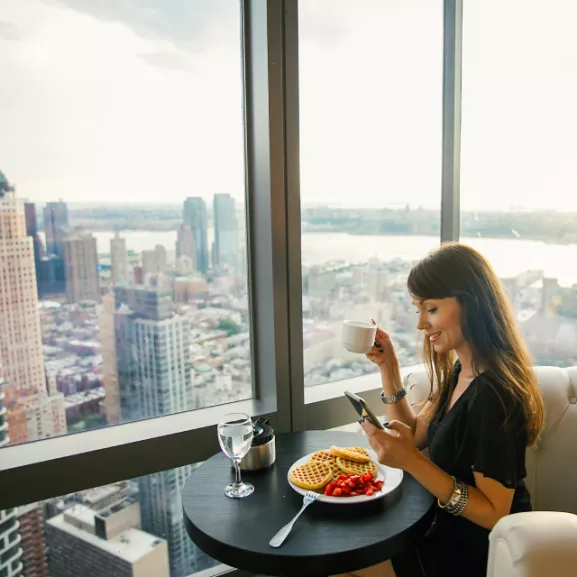 A woman at a table with food and coffee.